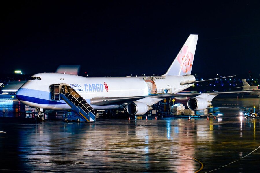 Cargo aircraft being loaded at an airport at night